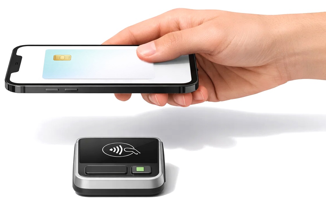 Hand holding smartphone with payment terminal